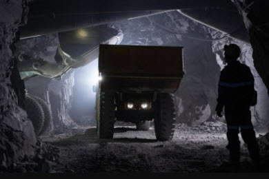 miners wearing safety gear walking through mine