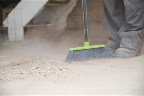 broom sweeping dust on floor