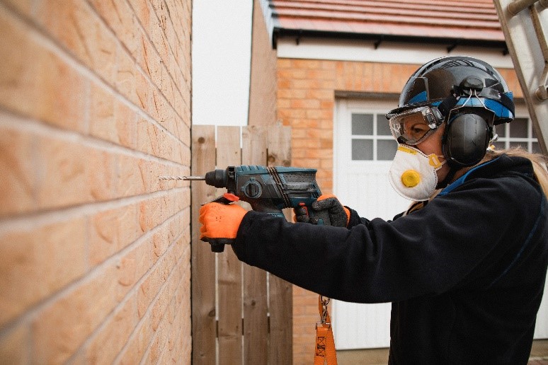 Worker drilling into bricks